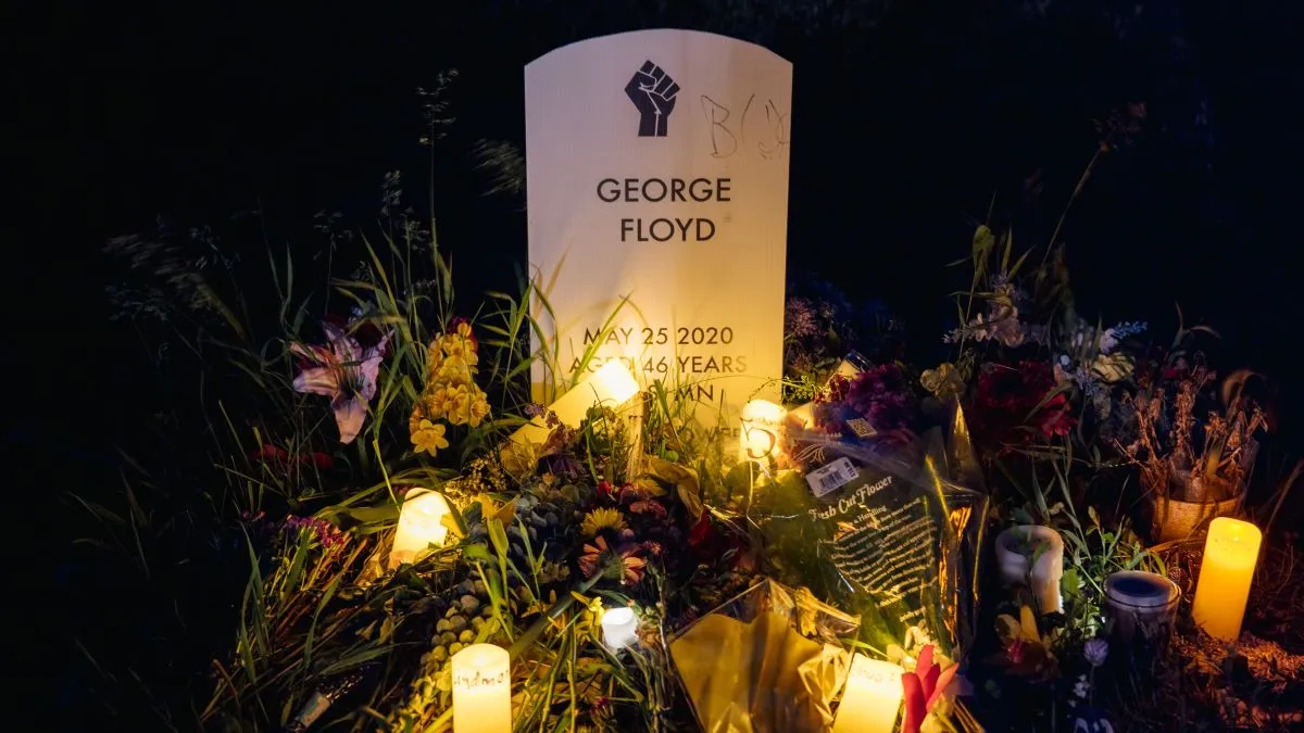 Candles illuminate a makeshift headstone for George Floyd at the Say Their Names Cemetery on May 25, 2021 in Minneapolis, Minnesota. People gathered to remember Floyd, who died at the hands of former Minneapolis police officer Derek Chauvin one year ago today. Chauvin was found guilty on three counts of murder and manslaughter. (Photo by Brandon Bell/Getty Images)